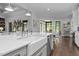 Open kitchen with bright white countertops, farmhouse sink, and stainless appliances at 2112 Colin Hill Ct, Wake Forest, NC 27587