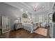 This spacious main bedroom features wood floors, accent wall, and a chandelier at 2112 Colin Hill Ct, Wake Forest, NC 27587