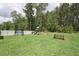 Lush backyard with a trampoline, picnic table, and a playset at 237 Emory Bluffs Dr, Holly Springs, NC 27540