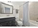 Well-lit bathroom featuring a shower/tub combo with tiled walls and neutral colors at 237 Emory Bluffs Dr, Holly Springs, NC 27540