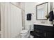 Well-lit bathroom with a shower-tub combo, a dark vanity, and stylish tile at 237 Emory Bluffs Dr, Holly Springs, NC 27540