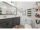 Well-lit bathroom featuring a double sink vanity, framed mirrors, and framed art pieces at 237 Emory Bluffs Dr, Holly Springs, NC 27540