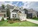Charming two-story home with a manicured lawn and a two-car garage in a suburban neighborhood at 237 Emory Bluffs Dr, Holly Springs, NC 27540