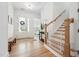Bright foyer featuring hardwood floors, a staircase with white railings, and a glimpse into other rooms at 237 Emory Bluffs Dr, Holly Springs, NC 27540