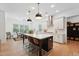 Modern kitchen featuring a large island with seating, stainless steel appliances, and white cabinetry at 237 Emory Bluffs Dr, Holly Springs, NC 27540