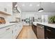Well-appointed kitchen with stainless steel appliances, white cabinets, and a large island with a farmhouse sink at 237 Emory Bluffs Dr, Holly Springs, NC 27540