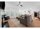 Spacious living room with hardwood floors, a fireplace, and an open layout flowing into the kitchen and dining area at 237 Emory Bluffs Dr, Holly Springs, NC 27540