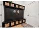 Organized mudroom with black shelving and storage baskets creates a tidy entryway at 237 Emory Bluffs Dr, Holly Springs, NC 27540