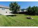 Backyard features lush green grass, mature trees, a fire pit, and a wood privacy fence at 2826 Tulip Poplar Cir, Durham, NC 27704