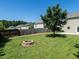Backyard features lush green grass, mature trees, a fire pit, and a wood privacy fence at 2826 Tulip Poplar Cir, Durham, NC 27704