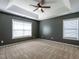 Spacious bedroom with tray ceiling, carpet flooring, and ample natural light at 2826 Tulip Poplar Cir, Durham, NC 27704