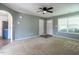 Living room showcasing neutral carpet, gray walls, modern ceiling fan, and entryways to other rooms at 2826 Tulip Poplar Cir, Durham, NC 27704