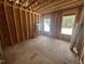 Unfinished bedroom with exposed framing, windows, and plywood flooring at 30 Cherry Bark Dr, Youngsville, NC 27596