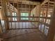 Unfinished interior view featuring exposed wood framing, windows, and subflooring throughout at 30 Cherry Bark Dr, Youngsville, NC 27596