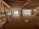 Unfinished living room featuring an open floor plan, exposed beams, and natural light from sliding glass doors at 30 Cherry Bark Dr, Youngsville, NC 27596