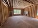 Unfinished living room featuring exposed beams, and framing for windows overlooking the wooded property at 30 Cherry Bark Dr, Youngsville, NC 27596