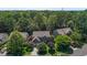 Aerial view of a traditional brick home with mature trees and lush landscaping in a well-established neighborhood at 308 Sutton Glen Dr, Apex, NC 27523