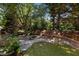 Landscaped backyard with stone patio, fire pit, and swing set, providing a relaxing outdoor space at 308 Sutton Glen Dr, Apex, NC 27523