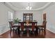 Formal dining room featuring elegant dark wood furniture, chandelier lighting, and refined decor at 308 Sutton Glen Dr, Apex, NC 27523