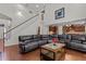 Open-concept living room with stairway access, kitchen view, and hardwood flooring at 308 Sutton Glen Dr, Apex, NC 27523