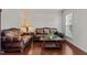Inviting living room featuring a classic brown leather sofa set and bright natural lighting at 308 Sutton Glen Dr, Apex, NC 27523