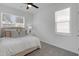 Cozy bedroom with a ceiling fan, neutral walls, plush carpeting, and natural light from two windows at 3636 Water Mist Ln, Raleigh, NC 27604