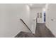 Clean hallway with carpeted stairs, a wooden banister, and access to multiple rooms at 3636 Water Mist Ln, Raleigh, NC 27604