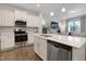 Bright, open kitchen with a center island, stainless steel appliances, and white cabinetry at 3636 Water Mist Ln, Raleigh, NC 27604