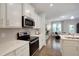 Modern kitchen featuring stainless steel appliances, white cabinets, and an open layout to the living area at 3636 Water Mist Ln, Raleigh, NC 27604