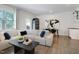 Open-concept living room with large windows, hardwood floors, modern decor and a view to the outdoor patio at 3636 Water Mist Ln, Raleigh, NC 27604