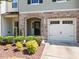 Welcoming front entry with stone archway, manicured landscaping, and attached garage at 3810 Prince Noah Loop, Wake Forest, NC 27587