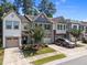 Street view of townhomes with lush landscaping, single car garages, and driveways at 3810 Prince Noah Loop, Wake Forest, NC 27587
