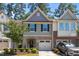 Charming townhome featuring stone accents, green siding, and a single car garage at 3810 Prince Noah Loop, Wake Forest, NC 27587