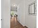 Inviting hallway featuring wood floors, white walls and trim, and an eye-catching decorative mirror at 3810 Prince Noah Loop, Wake Forest, NC 27587