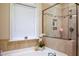 Bathroom featuring corner jetted tub with tile surround and glass shower at 4203 Overcup Oak Ln, Cary, NC 27519