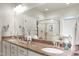 Bathroom featuring double sinks, granite countertop, and large mirror and walk-in glass shower at 4203 Overcup Oak Ln, Cary, NC 27519