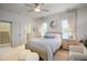 Bright bedroom featuring a ceiling fan, bedside tables, and large windows with white curtains at 4203 Overcup Oak Ln, Cary, NC 27519