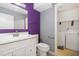 Cozy bathroom with purple accent wall, white vanity, and adjacent laundry area with washer and dryer at 4305 Lake Ridge Dr, Raleigh, NC 27604