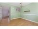 Bright dining room featuring a chandelier, light green walls, wood-look flooring, and a functional shelf at 4305 Lake Ridge Dr, Raleigh, NC 27604