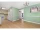 Open kitchen and dining area featuring light green walls, ample cabinet space, and light wood-look flooring at 4305 Lake Ridge Dr, Raleigh, NC 27604
