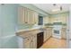 Well-lit kitchen features plentiful cabinetry, tile countertops, and modern appliances with black dishwasher at 4305 Lake Ridge Dr, Raleigh, NC 27604