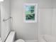Bathroom with sleek fixtures, a window offering backyard views, and a clean white tub and toilet at 5356 Baywood Forest Dr, Knightdale, NC 27545