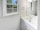 Bright bathroom featuring a white vanity, modern sink, and large mirror reflecting the natural light from the window at 5356 Baywood Forest Dr, Knightdale, NC 27545