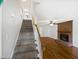 View of the carpeted stairs leading to a living area with hardwood floors and fireplace at 5356 Baywood Forest Dr, Knightdale, NC 27545