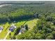 Aerial view showcasing the home surrounded by lush trees and a fenced pasture at 545 Olivia Way, Selma, NC 27576