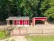 Aerial view of barns surrounded by green grass and mature trees, perfect for a horse farm at 545 Olivia Way, Selma, NC 27576