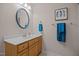 Well-lit bathroom featuring a single sink vanity with wood cabinets and blue accents at 545 Olivia Way, Selma, NC 27576