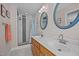 Bathroom featuring double sinks, wooden cabinets, and a tiled shower stall at 545 Olivia Way, Selma, NC 27576