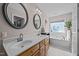 Bright bathroom featuring double sinks, a soaking tub, and a glass block window at 545 Olivia Way, Selma, NC 27576