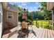 Outdoor living on the deck with table, chairs, and views of the backyard and mature trees at 545 Olivia Way, Selma, NC 27576